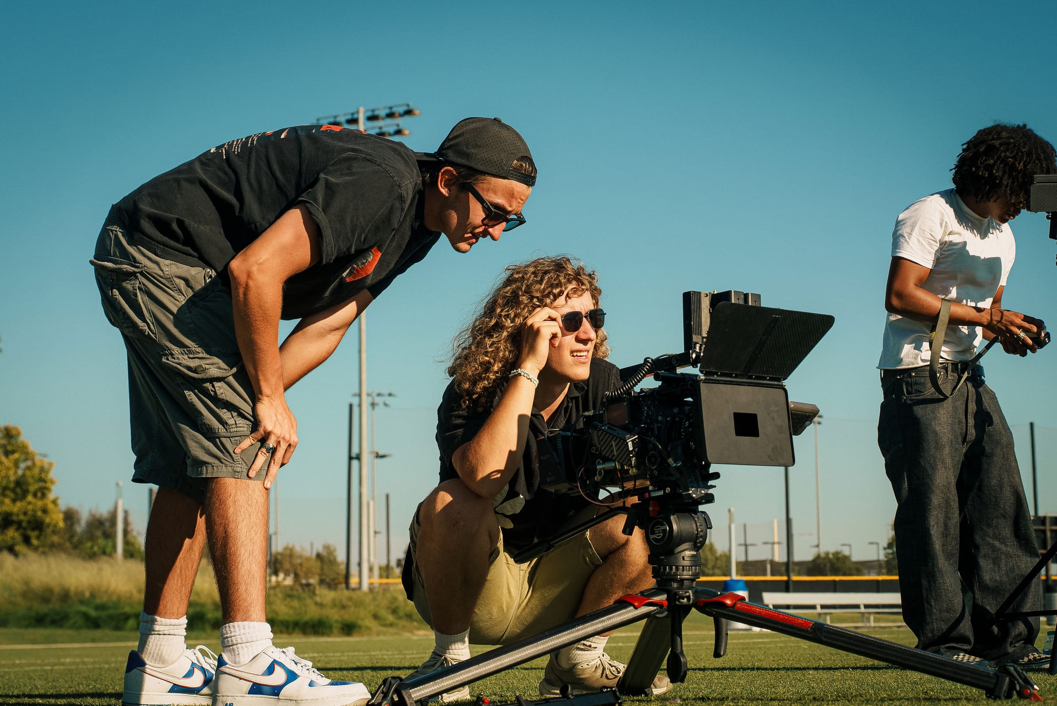 Two crew members watching a camera monitor on a football field